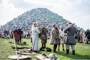 Grupa rekonstruktorów w&nbsp;historycznych strojach i&nbsp;z&nbsp;uzbrojeniem stoi na&nbsp;pierwszym planie, za nimi ogromny tłum widzów na&nbsp;wzgórzu.