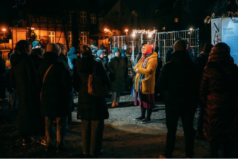 Tłum ludzi i&nbsp;oprowadzająca w&nbsp;Polskim Języku Migowym po Festiwalu.