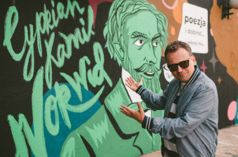 dyrektor NCK Rafał Wiśniewski na tle muralu