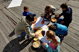 grupka dzieci tworzy mandalę