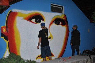 graficiarze rysują twarz na ścianie