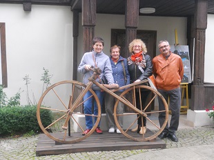 grupa osób z drewnianym rowerem