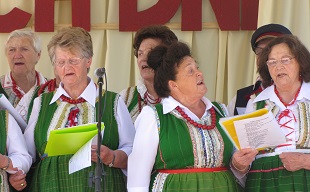 grupa śpiewających seniorek w strojach kurpiowskich