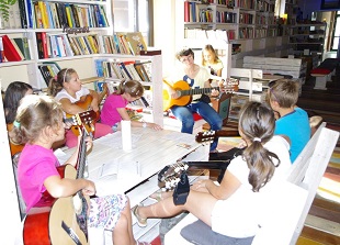 dzieci z gitarami wokół stołu